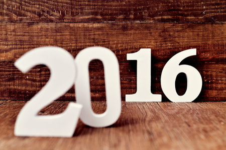three-dimensional white numbers forming the number 2016, as the new year, on a rustic wooden surface