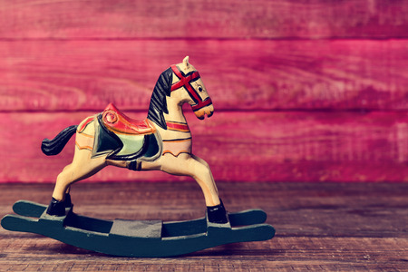 an old wooden rocking horse on a rustic wooden surfaceの写真素材