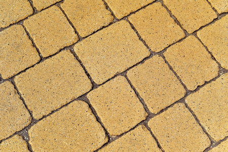 closeup of a yellow stone wall or a stone pavement background in diagonal