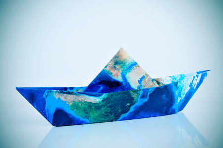 a paper boat made with a world map with a slight vignette added