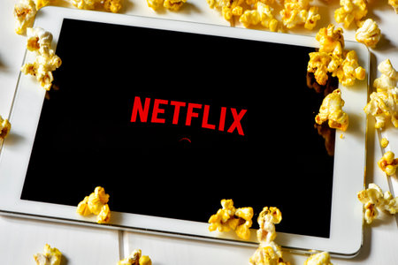 Barcelona, Spain - February 24, 2016: Popcorn and a tablet computer with the Netflix homepage in its screen. The provider of streaming movies and TV series was launched in Spain on October 2015のeditorial素材
