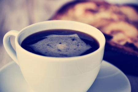 closeup of a cup of coffe and an apple cake on a rustic wooden tableの写真素材