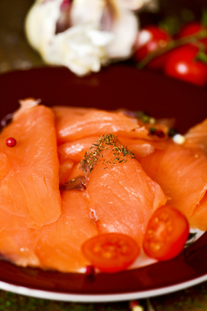 closeup of a plate with some slices of marinated smoked salmon served with dillの写真素材