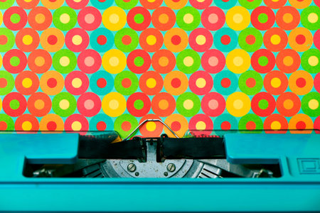 closeup of a colorful patterned paper in an old blue typewriter