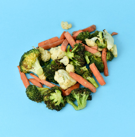 high-angle shot of some different sauteed vegetables, such as cauliflower, broccoli and carrot, on a blue backgroundの写真素材