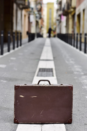 closeup of an old brown suitcase in the middle of a streetの写真素材