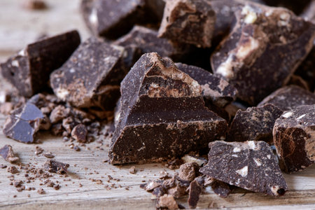 closeup of some pieces of dark chocolate on a rustic wooden surface