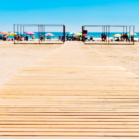 wooden boardwalk at the San Antonio Beach in Cullera, Spain, with the Mediterranean sea and...