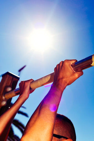 closeup of a young caucasian sportsman wearing sunglasses doing pull-ups outdoors