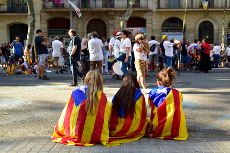 Barcelona, Spain - September 11, 2016: Girls covered with the separatist flag in a rally in support...