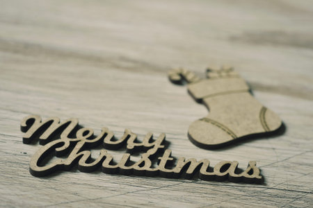 the text merry christmas made in wooden and a wooden ornament in the shape of a christmas stocking...