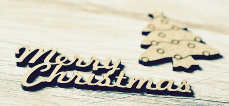 the text merry christmas made in wooden and a cozy ornament in the shape of a christmas tree on a...