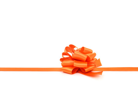an orange satin gift ribbon bow on a white background, with a negative space