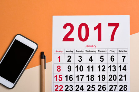 high-angle shot of a 2017 calendar, a smartphone and a pen on a desk