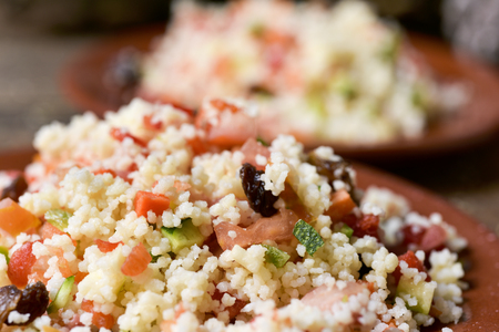 closeup of some earthenware plates with homemade tabbouleh, a typical levantine arab salad, on a rustic wooden tableの写真素材