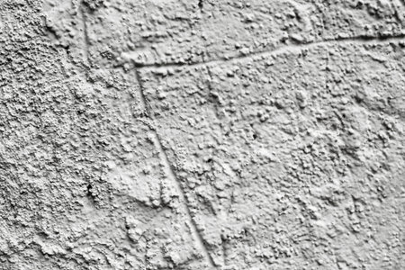 closeup of a rustic and cracked off-white plastered wall