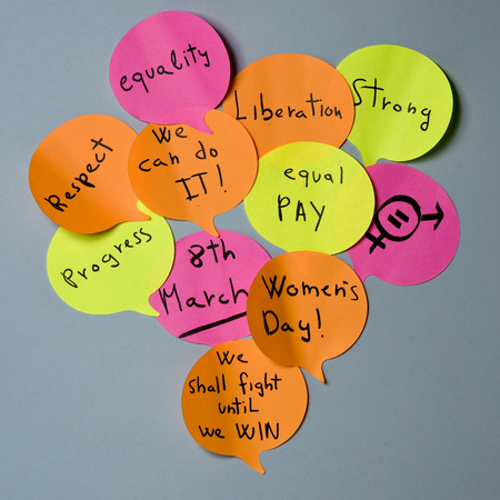 a cloud of sticky notes of different colors in the shape of speech balloons with concepts relative to the womens day written in it, such as equality respect, progress, liberation or equal payの写真素材