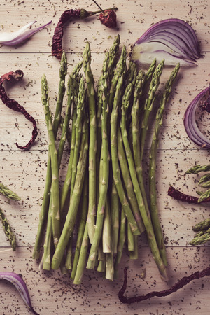 high-angle shot of a bunch of wild asparagus on a rustic wooden surfaceの写真素材