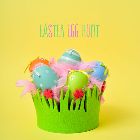 the text text easter egg hunt and a pile of different decorated easter eggs and pink feathers in a...