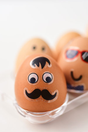 closeup of some easter eggs decorated with funny faces in a plastic egg tray