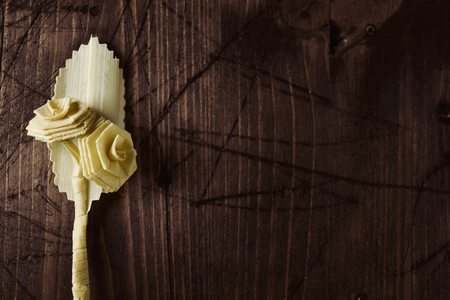 closeup of a small traditional spanish braided palm to be blessed on Palm Sunday on a rustic wooden surface with a blank spaceの写真素材