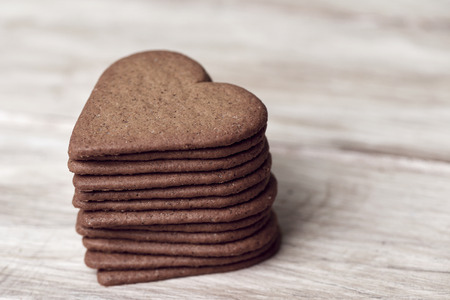 closeup of a pile of heart-shaped cookies on a rustic wooden tableの写真素材