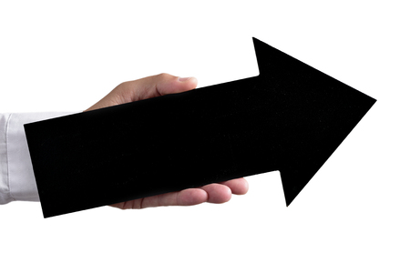 closeup of a young caucasian man holding a blank black arrow-shaped signboard pointing slightly upwardsの写真素材