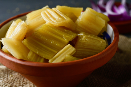 closeup of an earthenware bowl with cooked cardoon, typically eaten in Spain, on a rustic wooden tableの写真素材