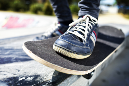 closeup of a young caucasian man skateboarding in an outdoors skate parkの写真素材