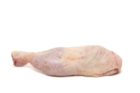closeup of a raw chicken leg on a white backgroundの写真素材