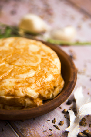 closeup of an earthenware plate with a typical tortilla de patatas, spanish omelet, on a rustic wooden tableの写真素材