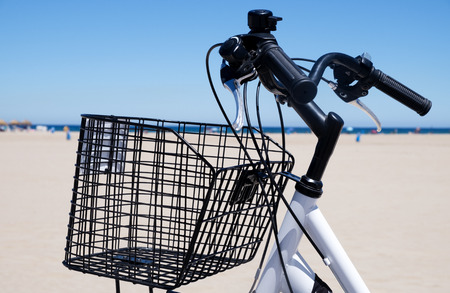 closeup of a bicycle with a basket on the beach, and the Mediterranean sea in the backgroundの写真素材