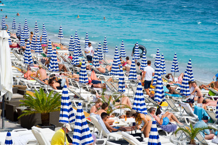 NICE, FRANCE - JUNE 4, 2017: People sunbathing on the beach in Nice, in the French Riviera, France, next to the Promenade des Anglais, the famous seafront walkway of the cityのeditorial素材