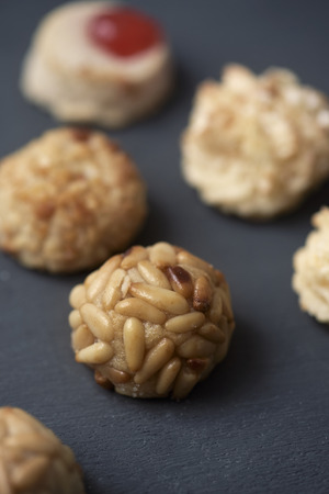 closeup of some panellets, typical confection eaten in All Saints Day in Catalonia, Spain, on a dark gray surfaceの写真素材