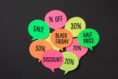 text black friday in an orange speech bubble and some other speech bubbles of different colors with different percentages of discount, against a dark gray backgroundの写真素材