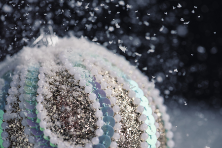 closeup of an elegant ornamented christmas ball on the snowの写真素材