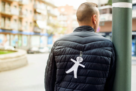 young man in the street with a paper man in his back as a prank for the dia de los inocentes, the...