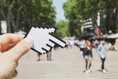 closeup of a young caucasian man pointing to the famous La Ramblas in Barcelona, Spain, with a hand-shaped mouse pointerの写真素材