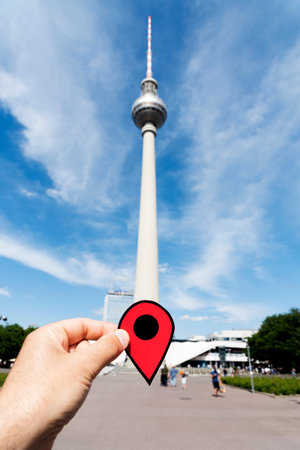 closeup of the hand of a young caucasian man with a red marker at the Berliner Fernsehturm, the...