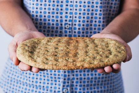 closeup of a caucasian man with a kale flatbread in his hands