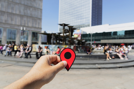 closeup of the hand of a young caucasian man with a red marker at the popular Alexanderplatz square in Berlin, Germanyの写真素材