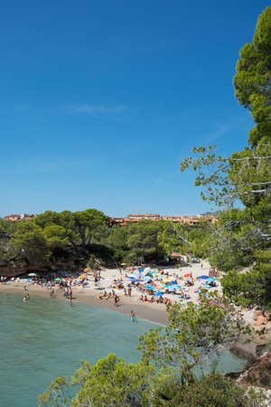 AMETLLA DE MAR, SPAIN - AUGUST 26, 2018: Vacationers at the Cala Calafato beach in Ametlla de Mar, Spain, in the popular Costa Daurada coastのeditorial素材