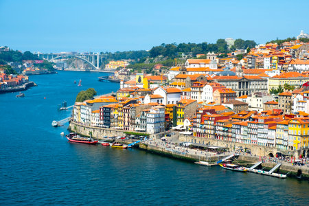 PORTO, PORTUGAL - AUGUST 29, 2018: A view of the Douro River and the old town of Porto, in Portugal, with its characteristic houses of different colors, and the Arrabida bridge in the backgroundのeditorial素材