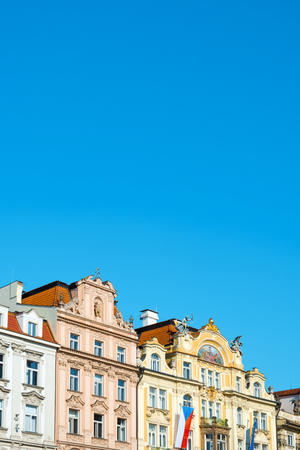 closeup of the top section of some ancient buildings in the old town of Prague, in the Czech Republic, with a blank space in the blue sky aboveの写真素材