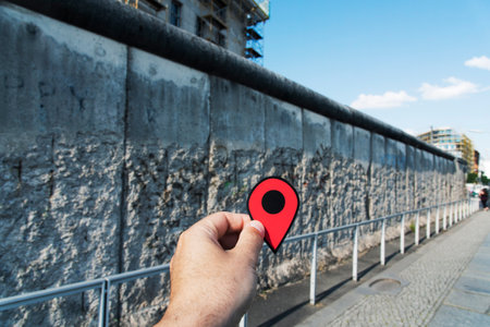 Closeup of the hand of a young caucasian man with a red marker at the Berlin Wall, in Berlin, Germanyのeditorial素材