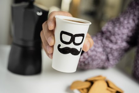 Closeup of a caucasian man with a disposable cup with coffee in his handsの写真素材