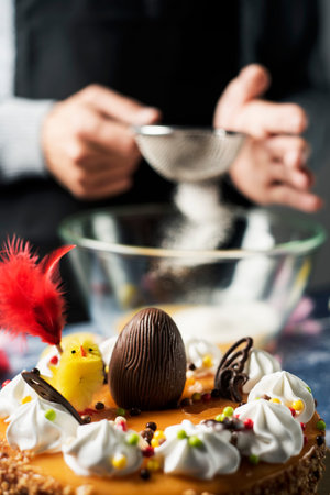 man preparing a typical mona de pascua, a cake eaten in Spain on Easter Monday, decorated with a...