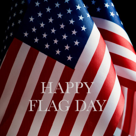 closeup of some american flags and the text happy flag day, against a black background