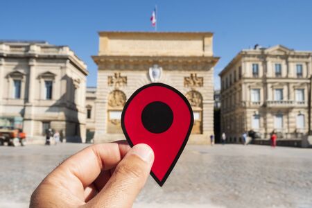 closeup of the hand of a caucasian man holding a red marker at the Porte du Peyrou gate in Montpellier, Franceの写真素材