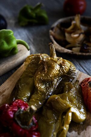 closeup of some grilled vegetables, such as red peppers, green peppers, tomato and onion, to prepare escalivada, a dish typical of Catalonia, Spain, on a tableの写真素材